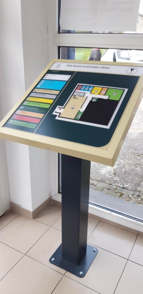 Wolnostojący tyflograficzny plan Klubu Seniora w Jastrzębiu-Zdroju przy wejściu do budynku.