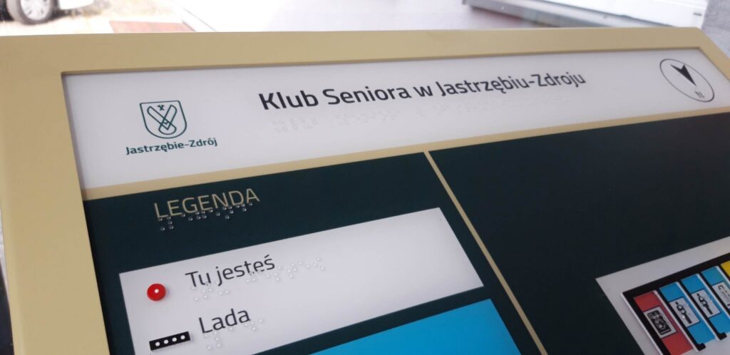 Górna część tyflograficznego planu Klubu Seniora w Jastrzębiu-Zdroju z napisami w alfabecie Braille’a
