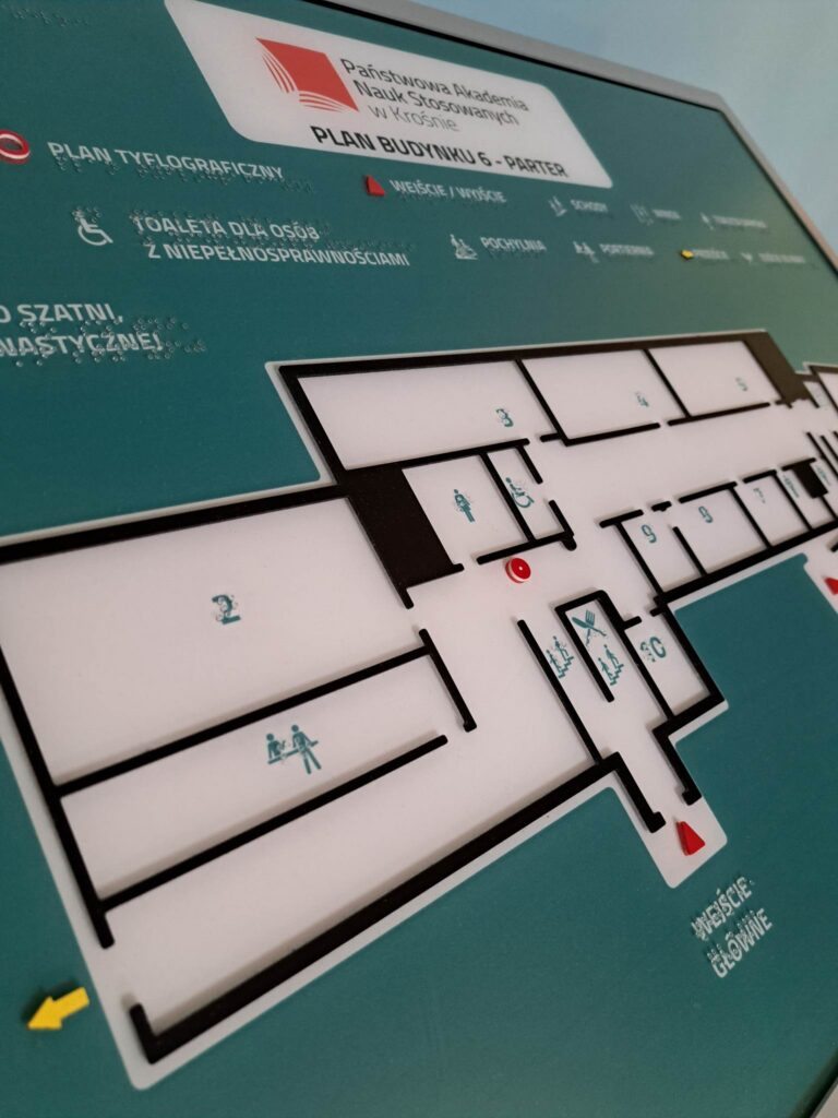 Plan budynku 6 z oznaczeniami pomieszczeń, wyjść, schodów i toalet, przedstawiony w formie tyflograficznej z opisami w brajlu.