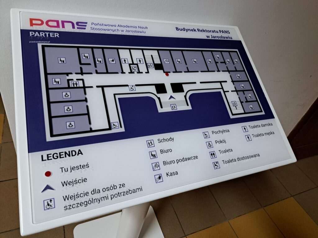 Tablica z planem parteru Rektoratu PANS w Jarosławiu, wyposażona w oznaczenia pomieszczeń i legendę w brajlu.