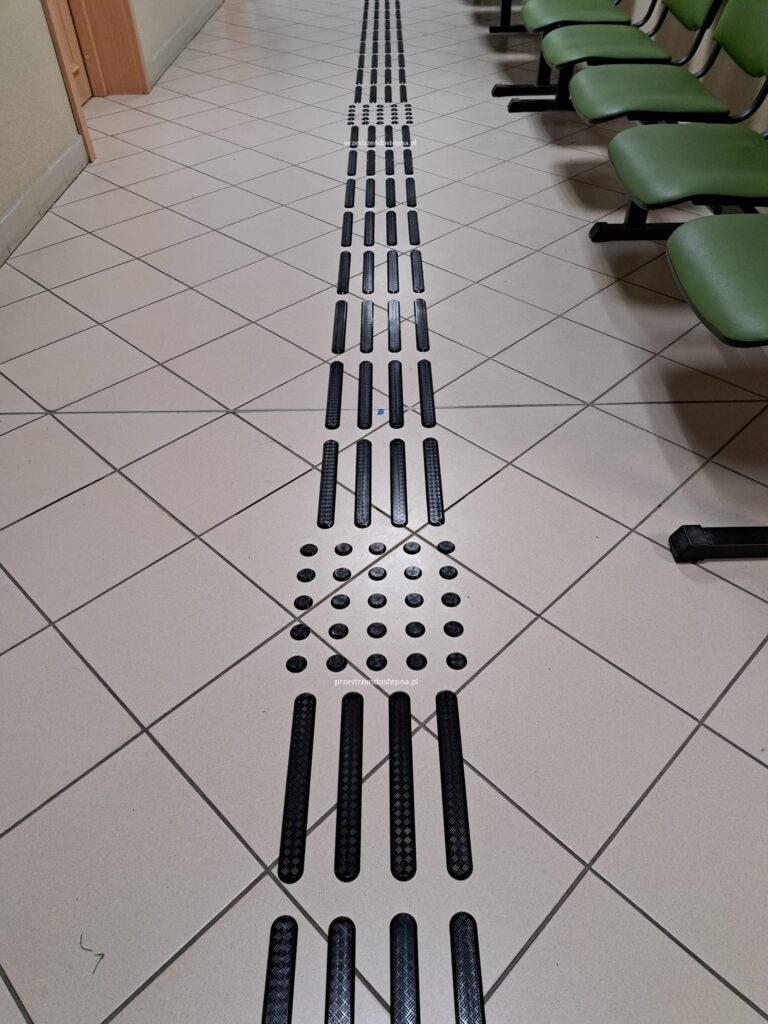 Ścieżka dotykowa prowadząca w korytarzu z polami uwagi.