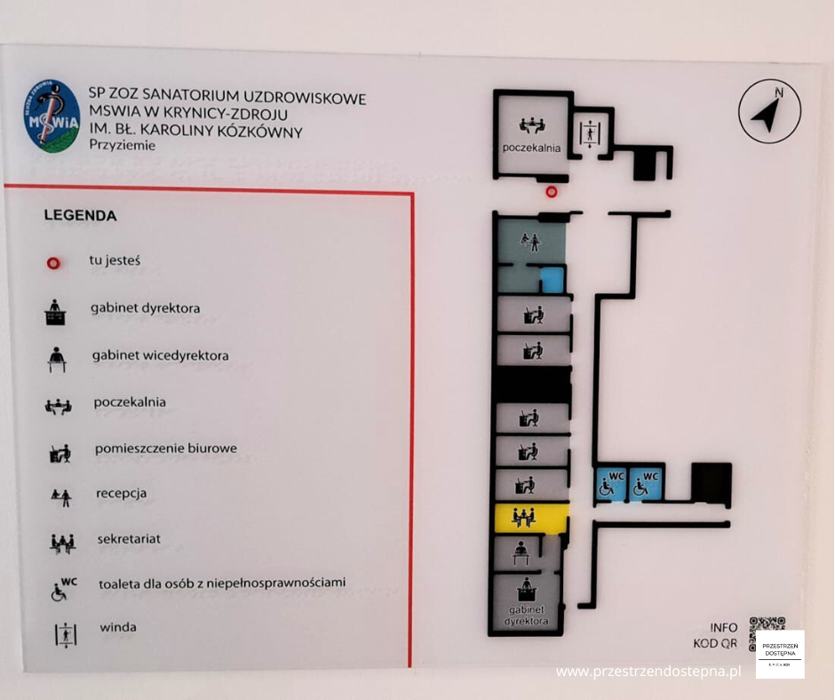 Mapa tyflograficzna parteru sanatorium z oznaczeniami pomieszczeń, windy i toalet dostępnych.