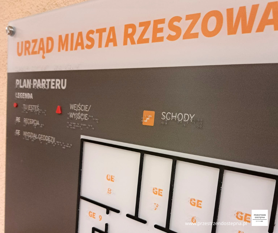 Dotykowy plan parteru z oznaczeniami wejścia, schodów i pomieszczeń.